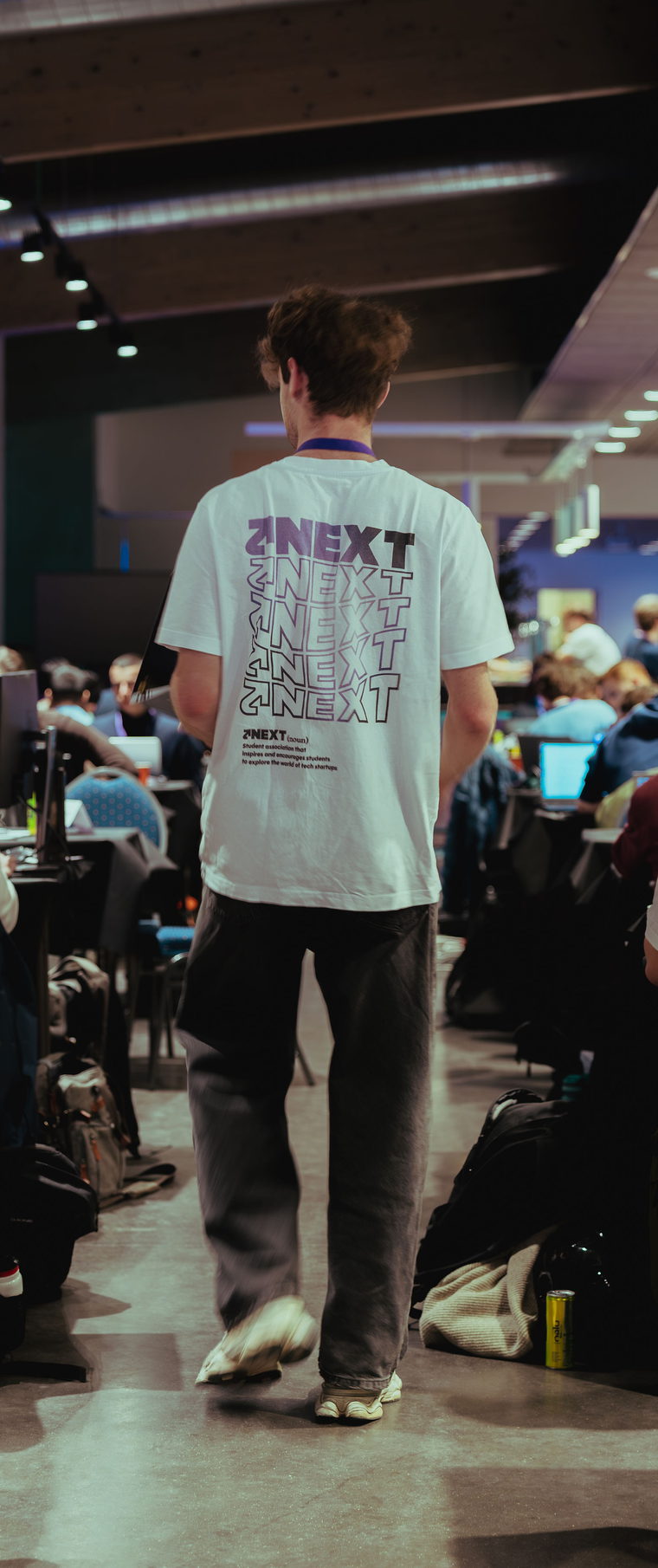 A participant crossing the work floor between the tables