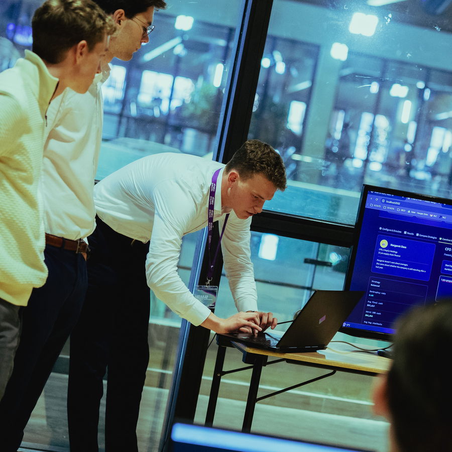 Two participants working through their code at a laptop by the window