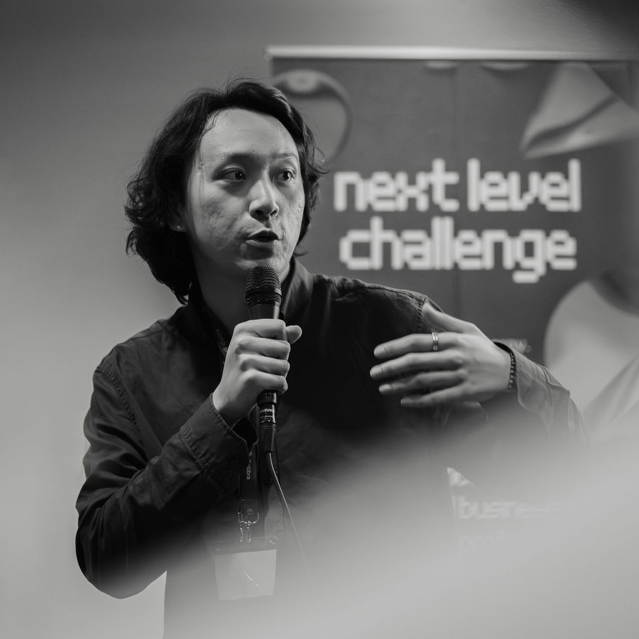 A speaker addressing the room, in black and white