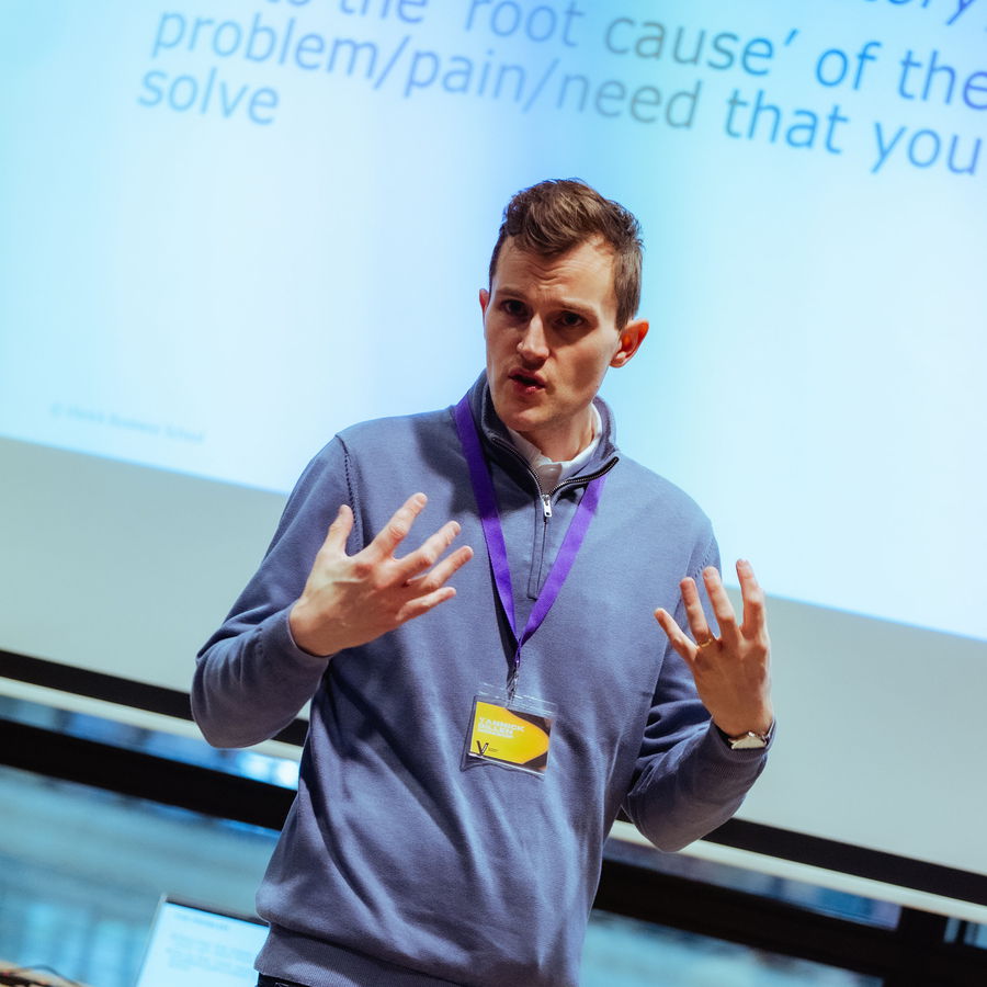 A coach running a workshop session in front of a slide
